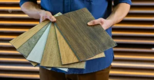 A man showcasing various types of vinyl flooring tiles, ideal for home interiors in Kerala. Learn how to choose the right vinyl flooring for your home.